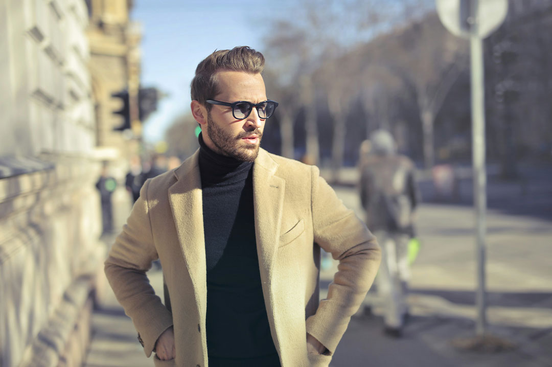 ragazzo con indosso un cappotto per strada