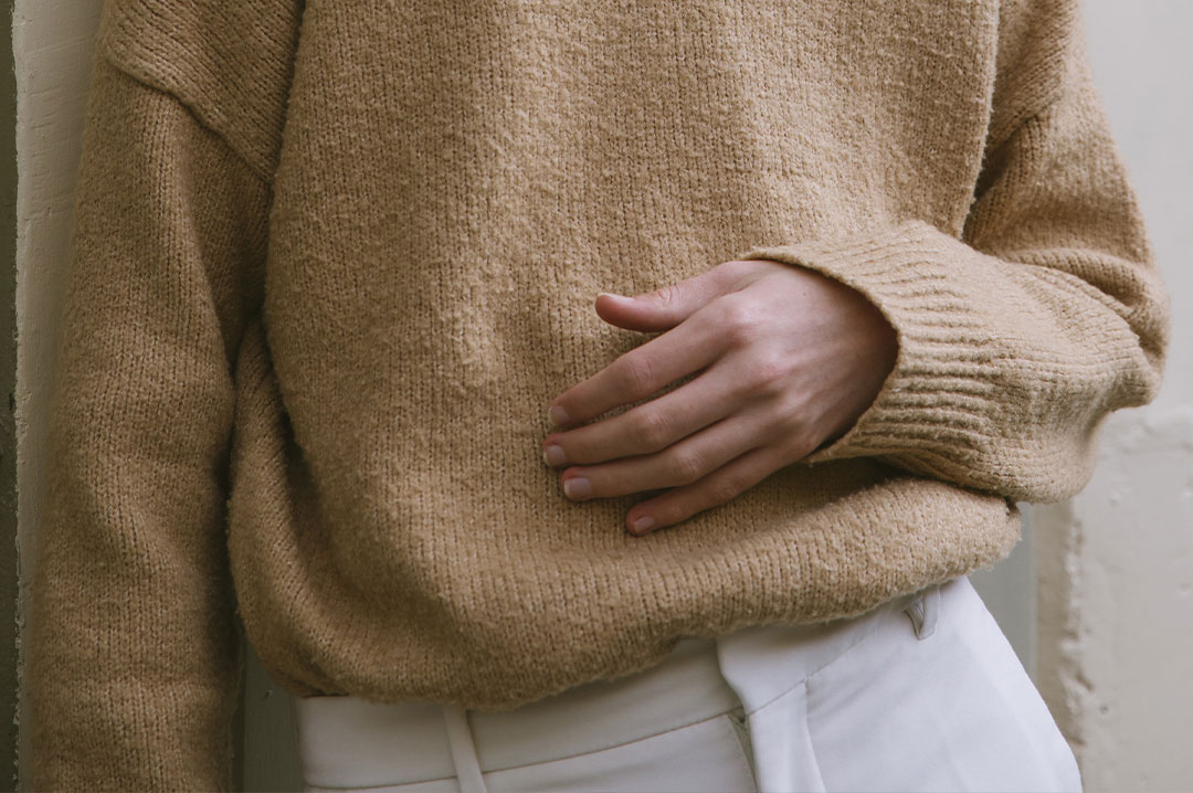 close up di un outfit beige e bianco di un ragazzo