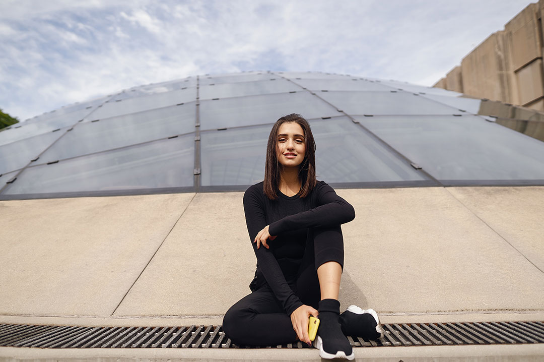 una ragazza vestita sportiva seduta all'aperto