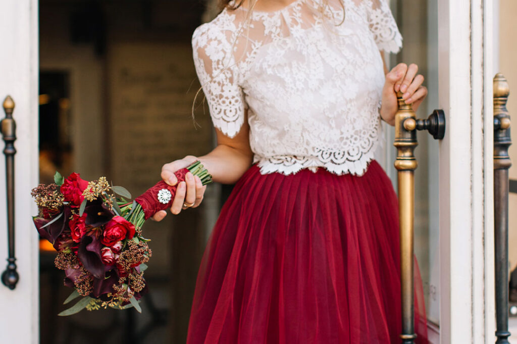 close up di una ragazza vestita per una cerimonia con in mano un mazzo di fiori