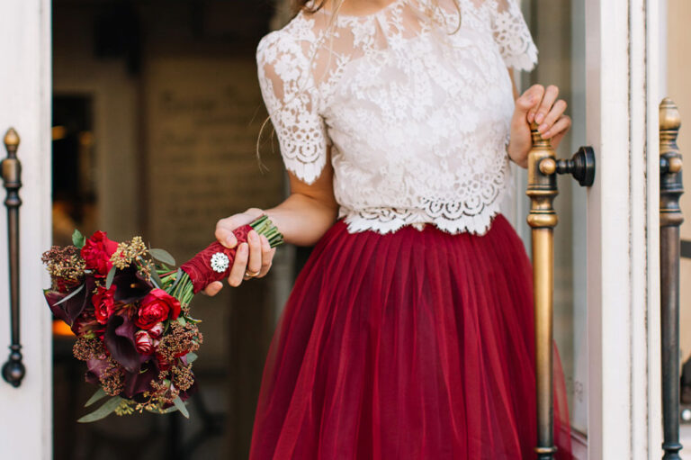 close up di una ragazza vestita per una cerimonia con in mano un mazzo di fiori